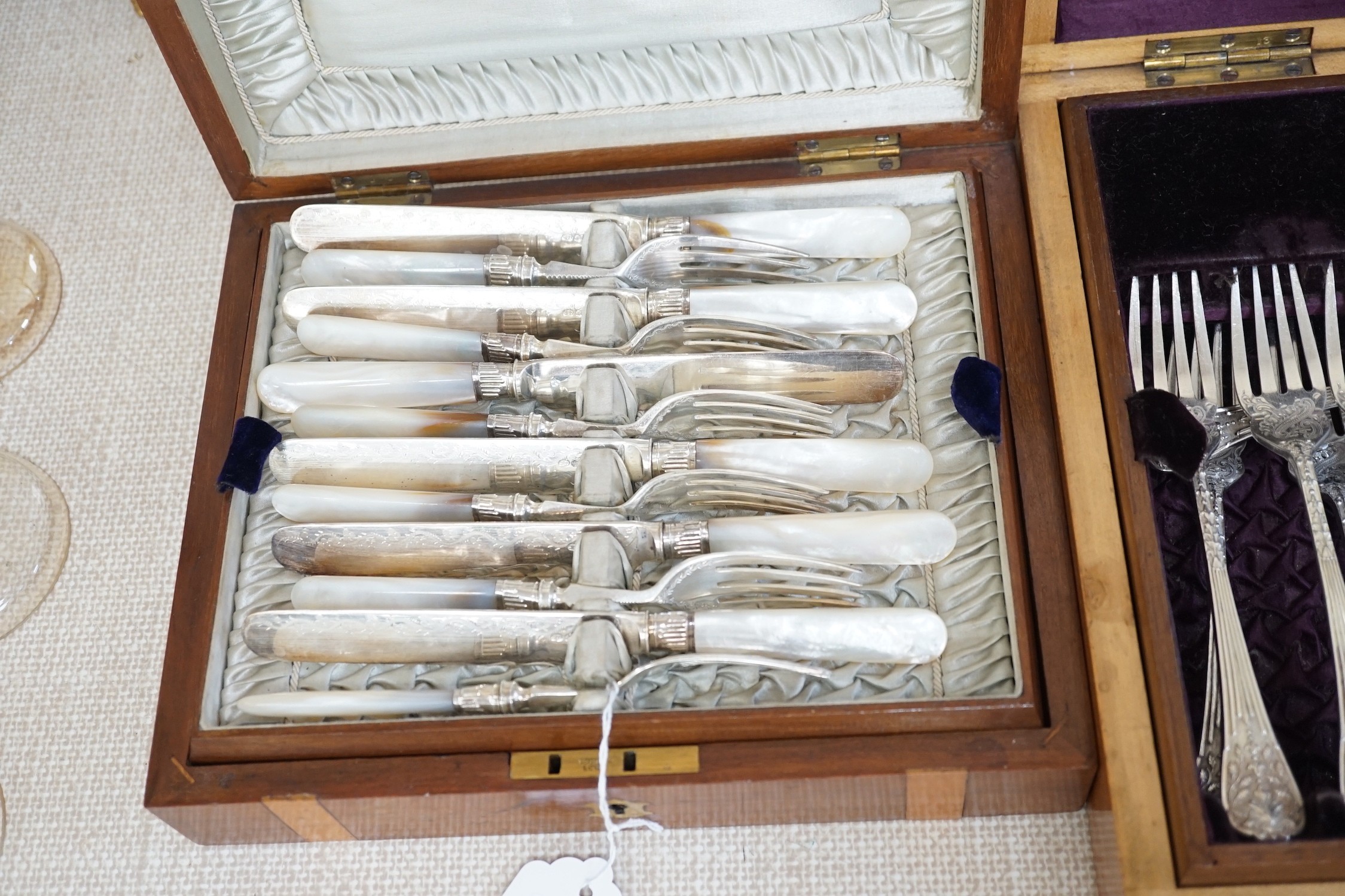 Two cased electroplate sets: a set of twelve fruit eaters and twelve fish knives and forks